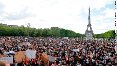 Un manifestant tient une banderole sur le Champ de Mars, à Paris le 6 juin 2020, dans le cadre des manifestations Black Lives Matter dans la ville.